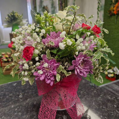 Rosy Glow - A charming and delicate arrangement featuring soft pink and deep purple blossoms, carefully arranged in a chic hatbox-style container. A perfect mix of elegance and romance.