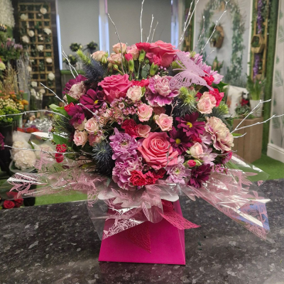 Pink Perfection - A bold and vibrant mix of pink and purple blooms, carefully arranged in a luxury pink gift box with intricate wrapping. A rich and dramatic floral choice for any occasion.