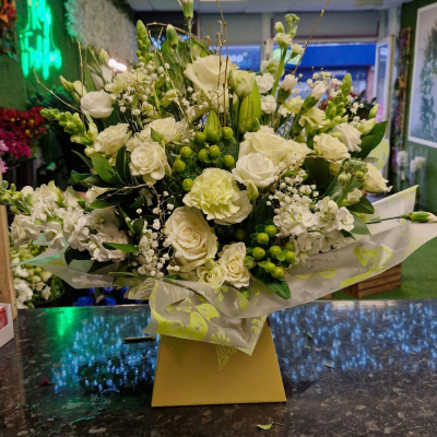 Cream Whisper - A soft and sophisticated bouquet of white and cream florals, accented with lush green hypericum berries. A classic and elegant arrangement, perfect for any occasion where a touch of purity and grace is needed.