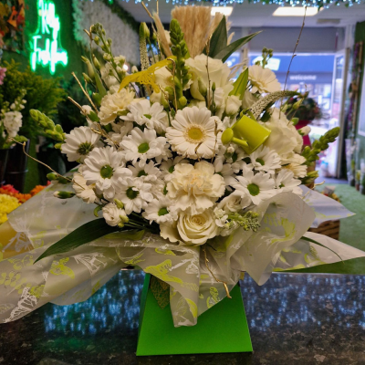 White Serenity - A refined and tranquil all-white arrangement, featuring delicate roses, lilies, carnations, and lush green foliage. Designed in a sleek white gift box, this arrangement is perfect for those who appreciate timeless elegance.